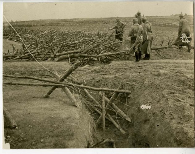 Német tisztek a fából és drótból lefektetett akadályt szemlélik az oroszoktól elfoglalt harcmezőn